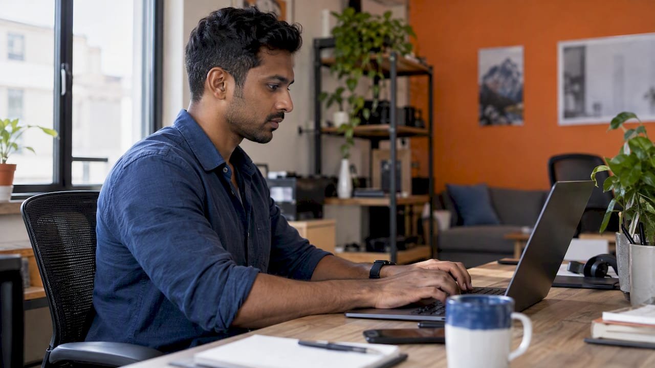 Marketer composing a prompt at a laptop